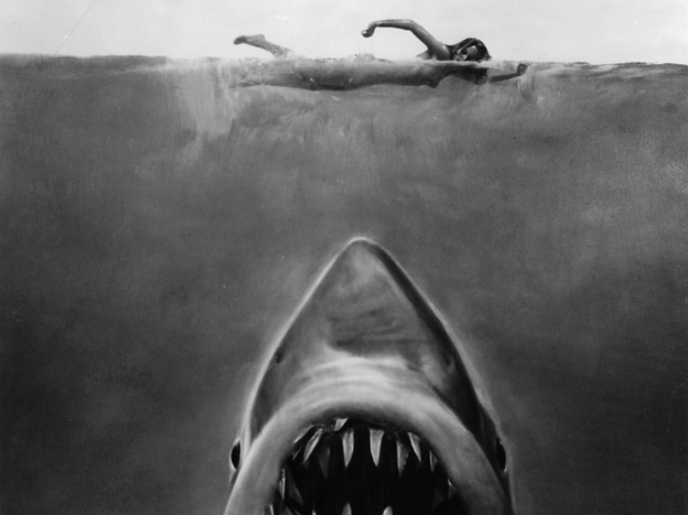 Susan Backlinie swims as the great white shark rises toward her in publicity art for the 1975 film Jaws.
