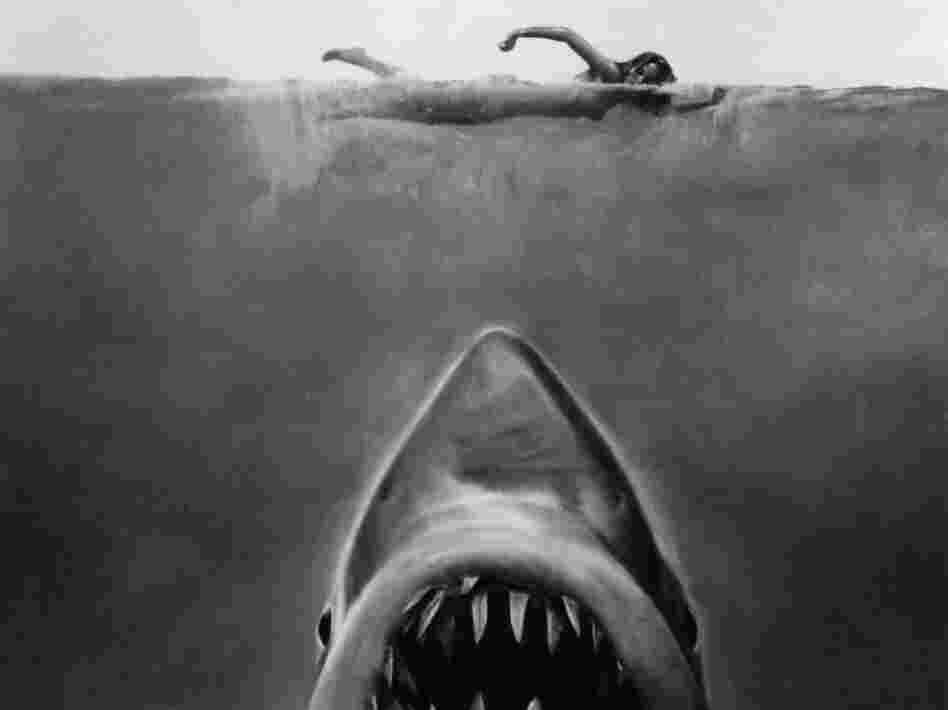 Susan Backlinie swims as the great white shark rises toward her in publicity art for the 1975 film Jaws.
