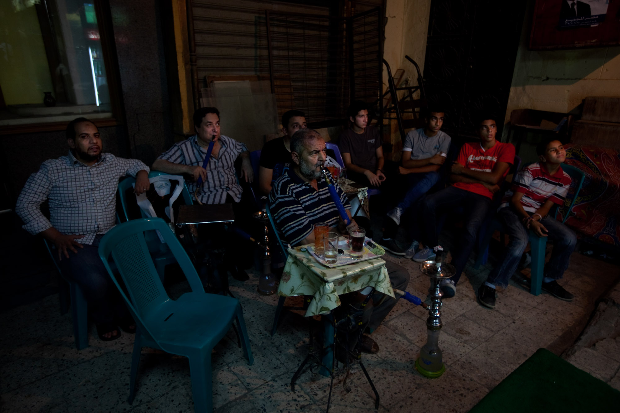 At the market, a small group gathers to watch England play France in a soccer match at the European championship. They're rooting for England.