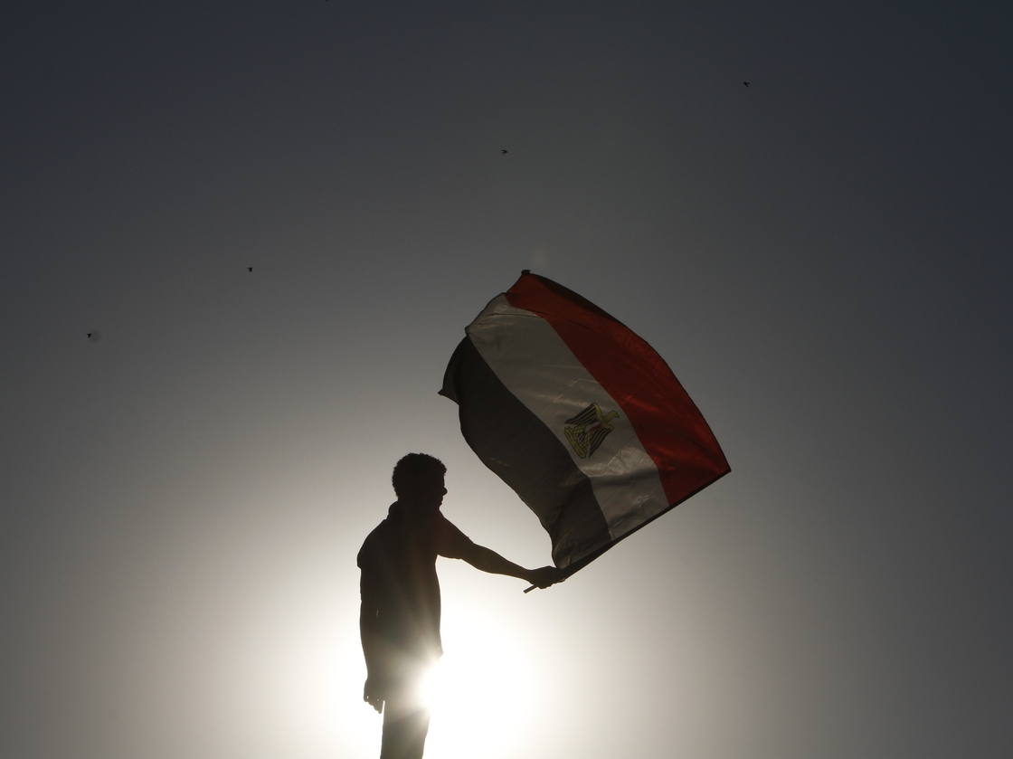 An Egyptian protester waves his national flag at sunset during a demonstration in Cairo's landmark Tahrir Square on June 5, 2012 to protest against verdicts handed down in ex-president Hosni Mubarak's murder trial.