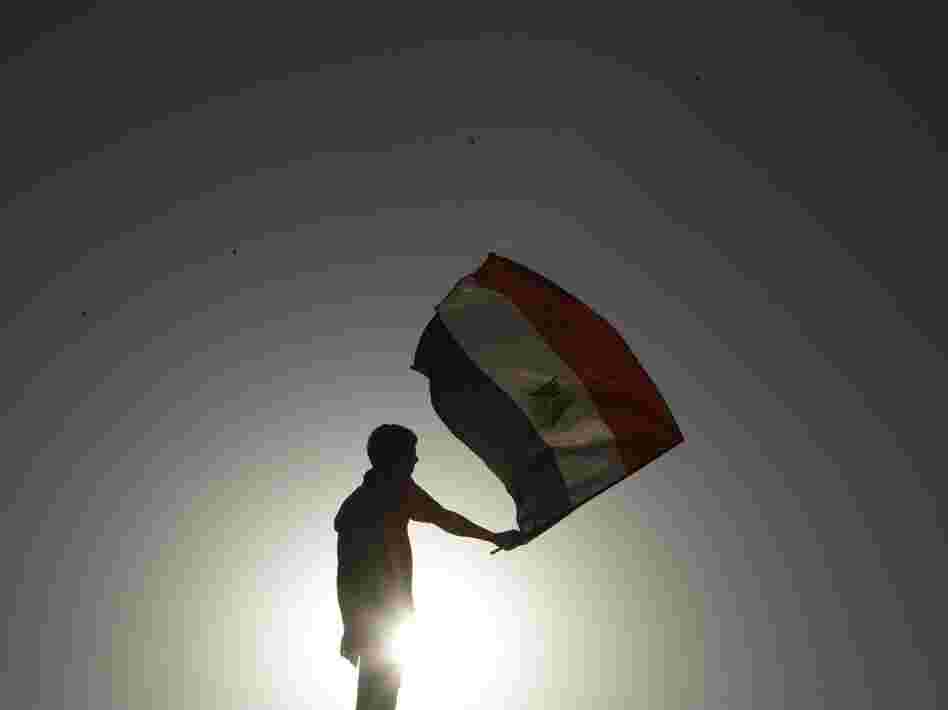 An Egyptian protester waves his national flag at sunset during a demonstration in Cairo's landmark Tahrir Square on June 5, 2012 to protest against verdicts handed down in ex-president Hosni Mubarak's murder trial.