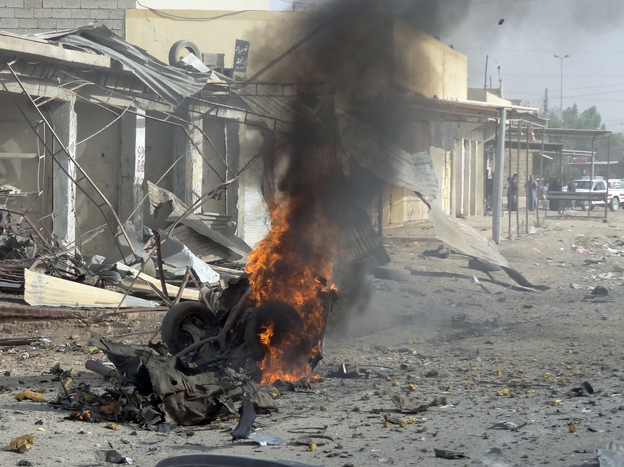 Smoke rises from the wreckage of a vehicle in Kirkuk, Iraq. A bomb in it exploded — one of a series of coordinated attacks today on Shiite Muslims across the country.