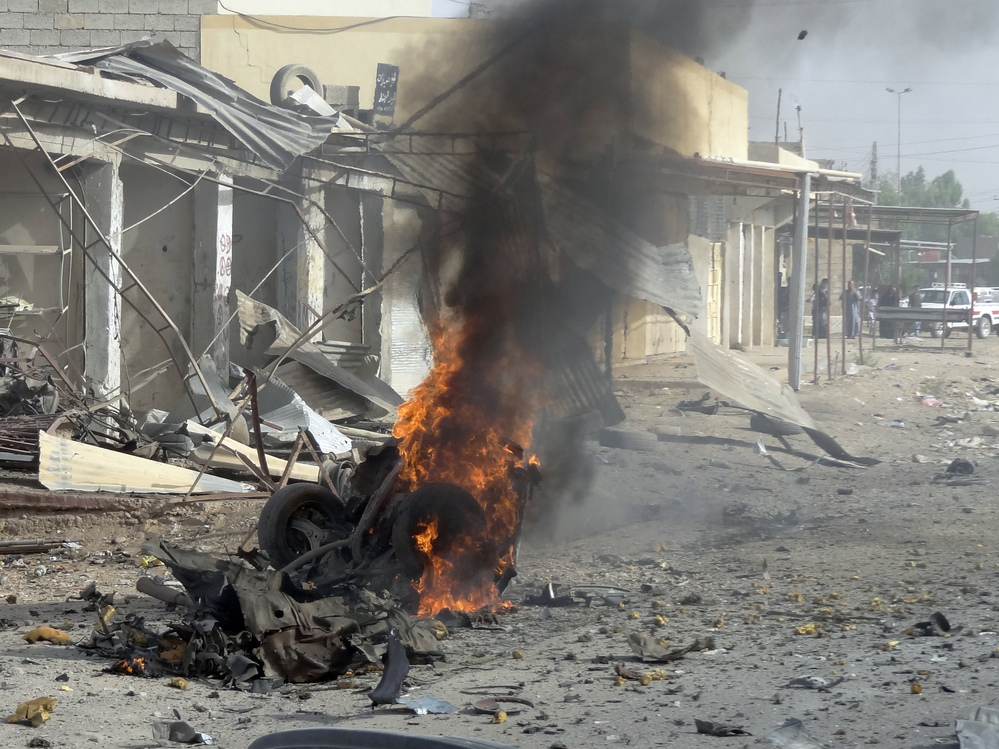 Smoke rises from the wreckage of a vehicle in Kirkuk, Iraq. A bomb in it exploded — one of a series of coordinated attacks today on Shiite Muslims across the country.