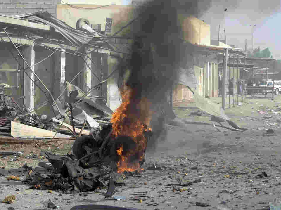 Smoke rises from the wreckage of a vehicle in Kirkuk, Iraq. A bomb in it exploded — one of a series of coordinated attacks today on Shiite Muslims across the country.