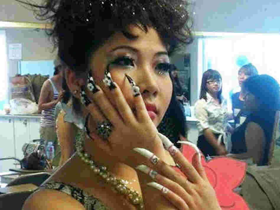 A model shows off an ABC student's work. Most of the students are studying manicuring.