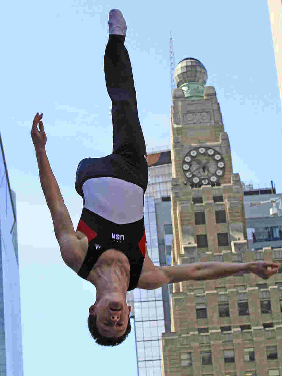 Jeffrey Gluckstein goes upside down on a trampoline in New York's Times Square during U.S. Olympic team festivities.