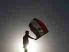 An Egyptian protester waves his national flag in Cairo. An Egyptian protester waves his national flag in Cairo.