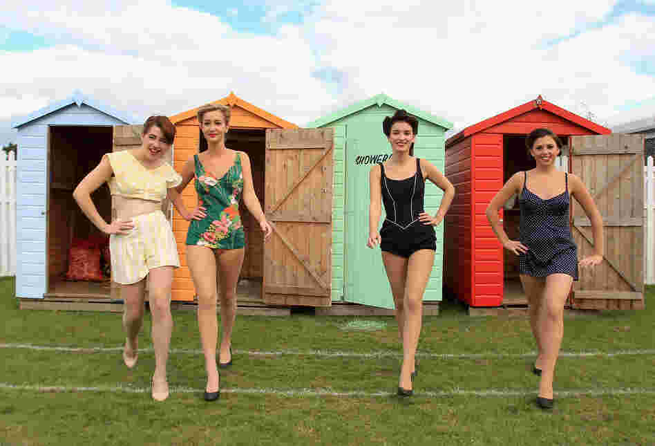 Women in vintage bikinis pose in the drivers' enclosure during Goodwood Revival 2010 in Chichester, England. The event was based around a classic car race meeting and air show but celebrated all things 1945-1966.