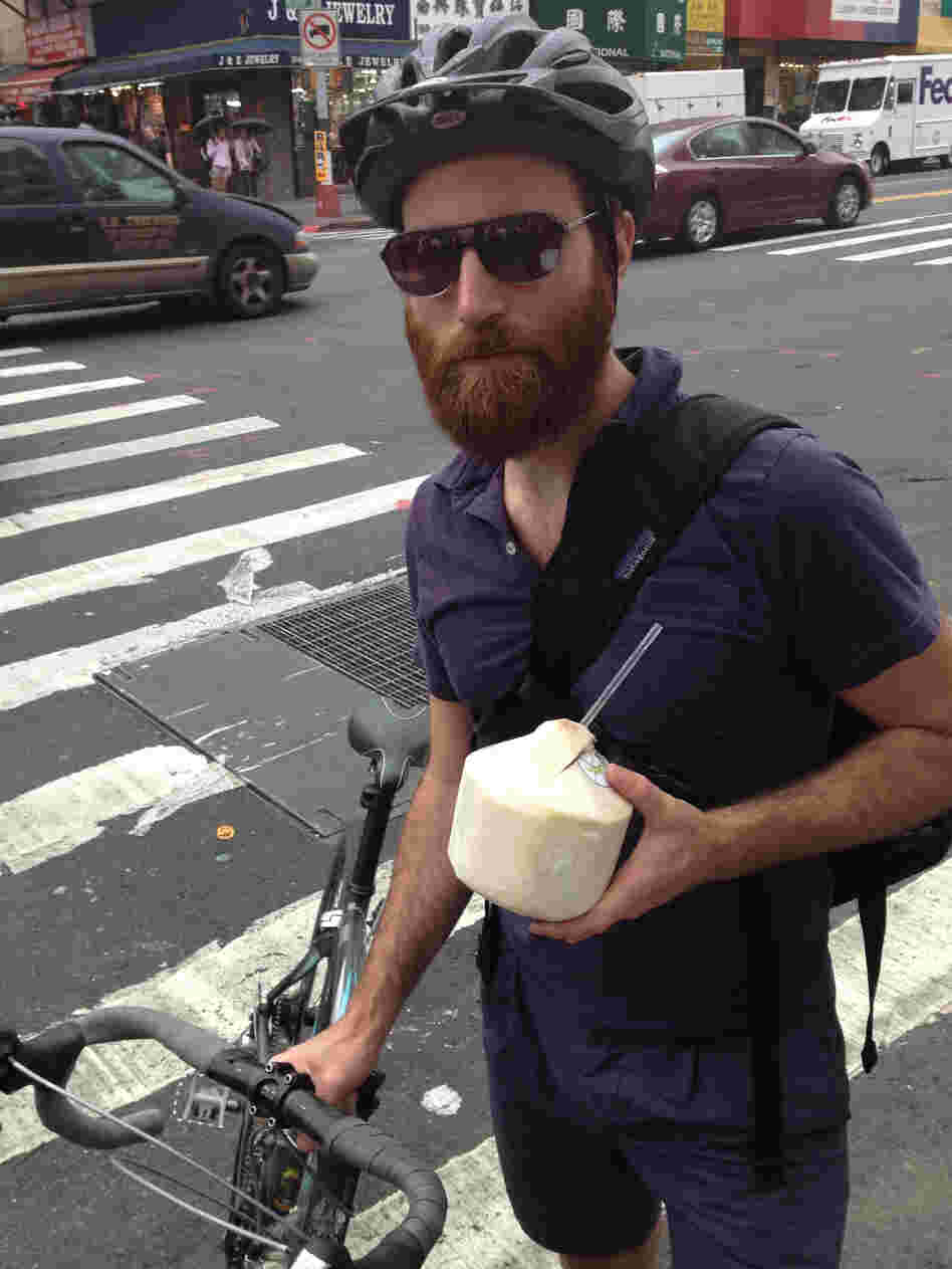 John Gordon Gauld, a 35-year old artist, bikes with coconut water in New York City.