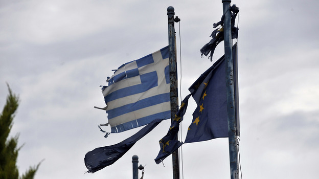 Torn Greek (left) and European Union flags fly at the entrance of an abandoned factory in the industrial zone of Komotini about 500 miles from Athens. Sunday's parliamentary election will go a long way toward determining whether Greece stays in the EU.