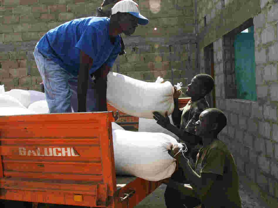 Putting bags of soybeans into makeshift storage at the farm called Rei do Agro. The farm's steel grain bins are still under construction.
