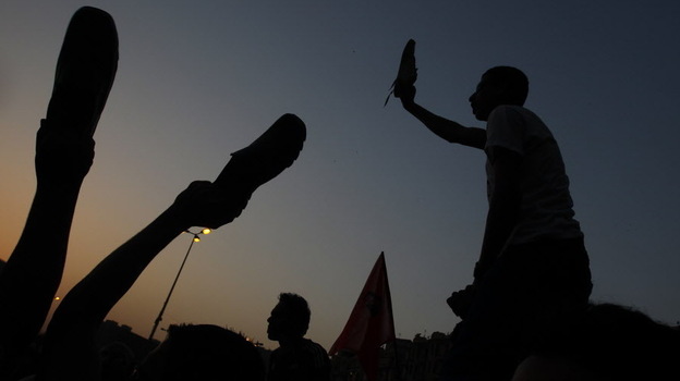 Egyptian anti-military protesters waved their shoes — a way of showing their extreme anger — as they demonstrated in Cairo's Tahrir Square on Thursday. More protests are planned for today.