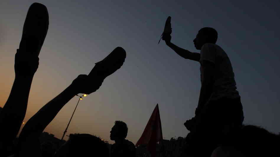 Egyptian anti-military protesters waved their shoes — a way of showing their extreme anger — as they demonstrated in Cairo's Tahrir Square on Thursday. More protests are planned for today.