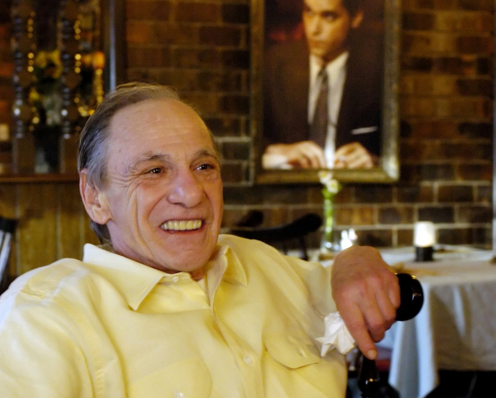 Henry Hill sits in the dining room of the Firefly restaurant in North Platte, Neb., in 2005. A portrait of actor Ray Liotta portraying Hill in the movie Goodfellas hangs on the wall behind him.