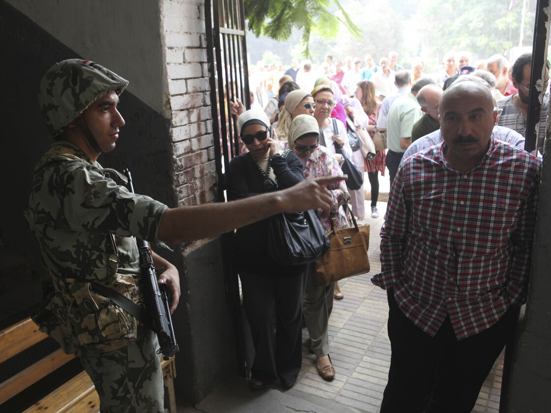 A soldier directs a voter inside a polling station on Saturday in Cairo. Egyptians voted Saturday in the country's landmark presidential runoff, choosing between Hosni Mubarak's ex-prime minister and an Islamist candidate from the Muslim Brotherhood after a race that has deeply polarized the nation.