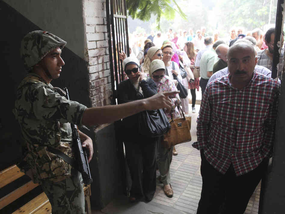 A soldier directs a voter inside a polling station on Saturday in Cairo. Egyptians voted Saturday in the country's landmark presidential runoff, choosing between Hosni Mubarak's ex-prime minister and an Islamist candidate from the Muslim Brotherhood after a race that has deeply polarized the nation.