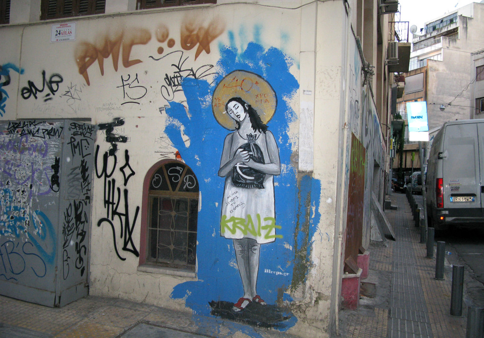 Graffiti in the rundown Athens neighborhood of Psiri depicts a woman clutching a sack of euros, a golden halo on her head and the title, "40 Years of Debt-ocracy." The street artist goes by the tag Bleeps.gr.