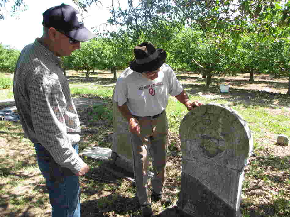 Tony Pires (right) inspects a repaired headstone for Mitchell Gilliam (Polly's father) with Jack Boatwright of the U.S. Geological Survey.