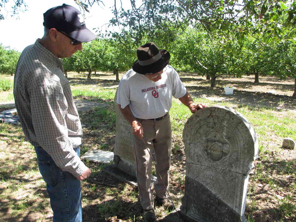Tony Pires (right) inspects a repaired headstone for Mitchell Gilliam (Polly's father) with Jack Boatwright of the U.S. Geological Survey.