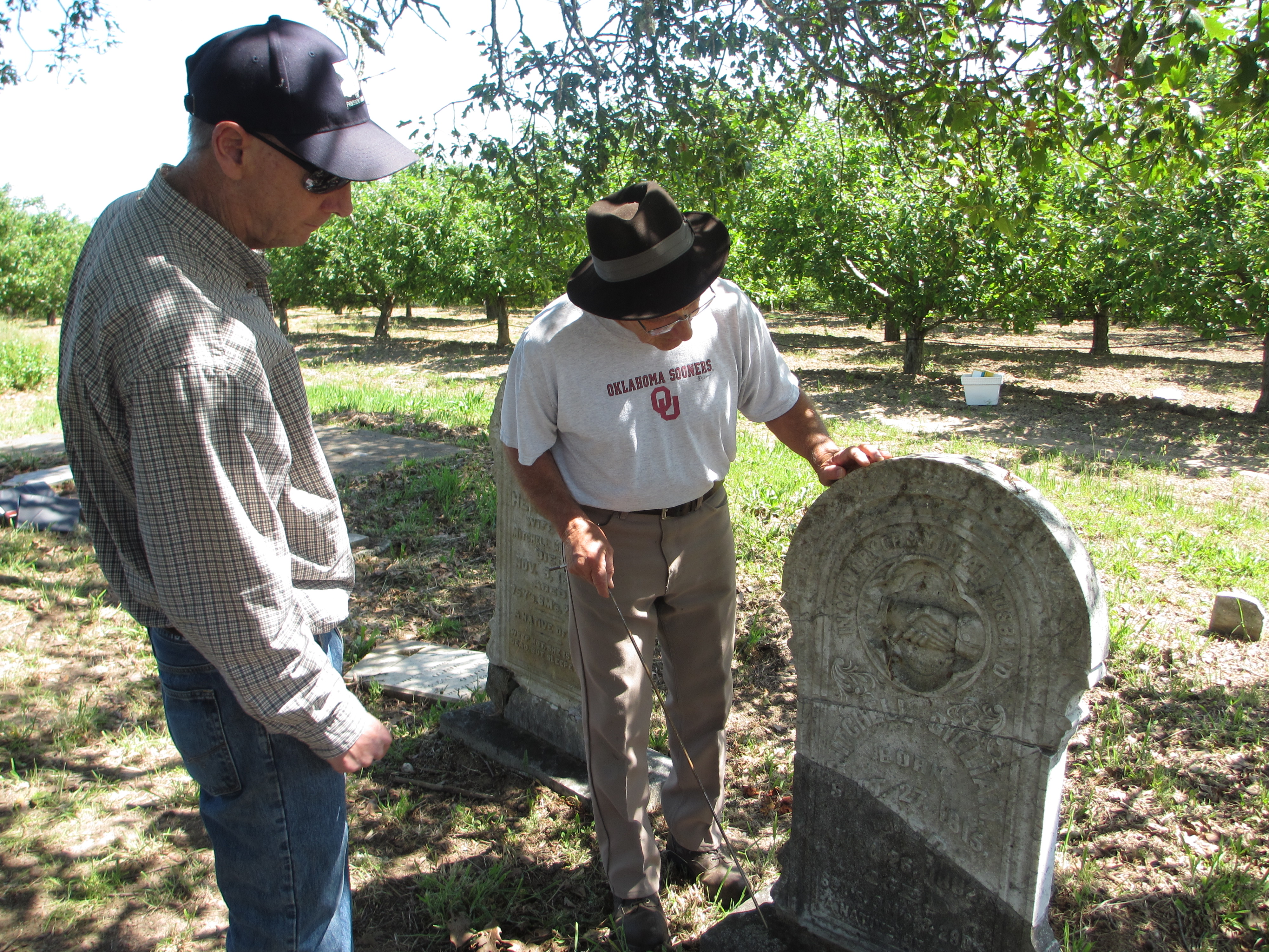 Tony Pires (right) inspects a repaired headstone for Mitchell Gilliam (Polly's father) with Jack Boatwright of the U.S. Geological Survey.