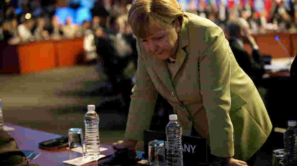 German Chancellor Angela Merkel speaks with members of her delegation before the first plenary session of the G-20 Leaders' Summit in Los Cabos, Mexico, on Monday.