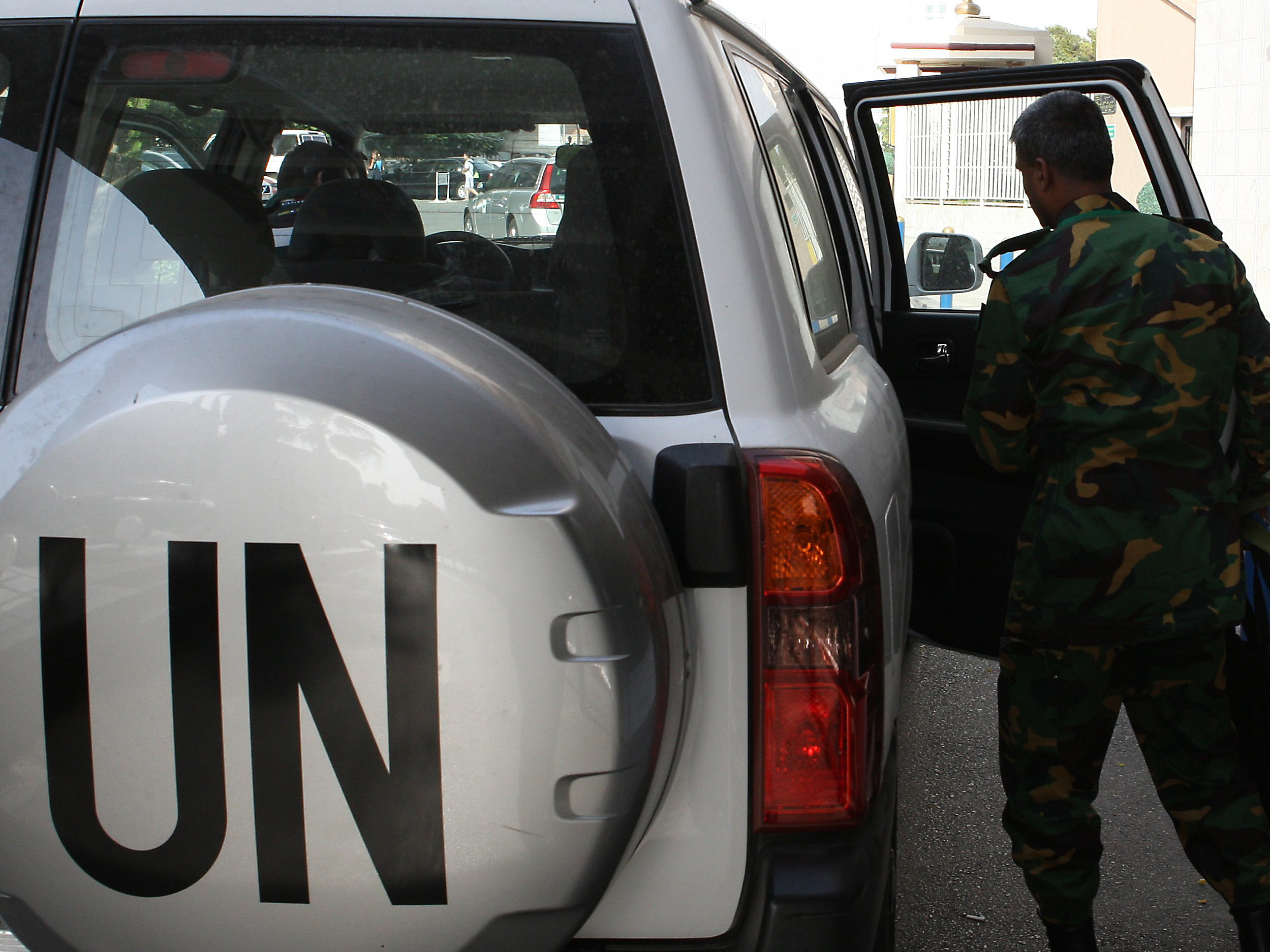 The United Nations observer team in Syria suspended its mission last Saturday, June 16, after facing repeated dangers and difficulties in trying to do its work. One observer is shown here next to a U.N. vehicle outside a hotel in Damascus. (Image credit: AFP/Getty Images)