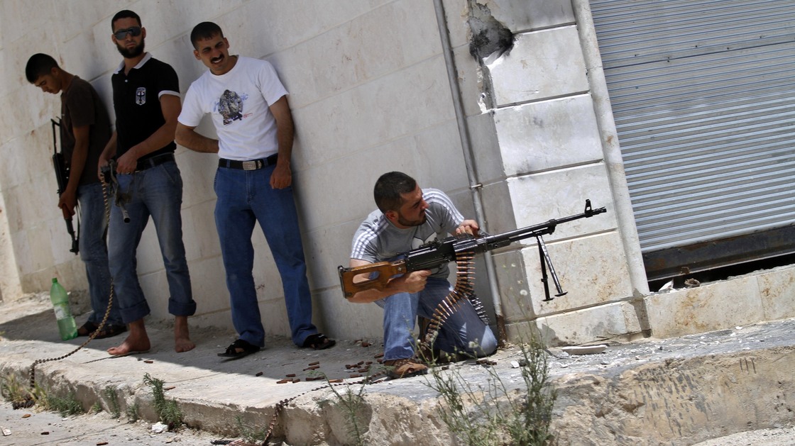 A Syrian rebel fires his weapon during clashes with Syrian troops near Idlib, in northern Syria, on June 15. The conflict has gone on for well over a year, but the international community has shown no appetite for a military intervention.