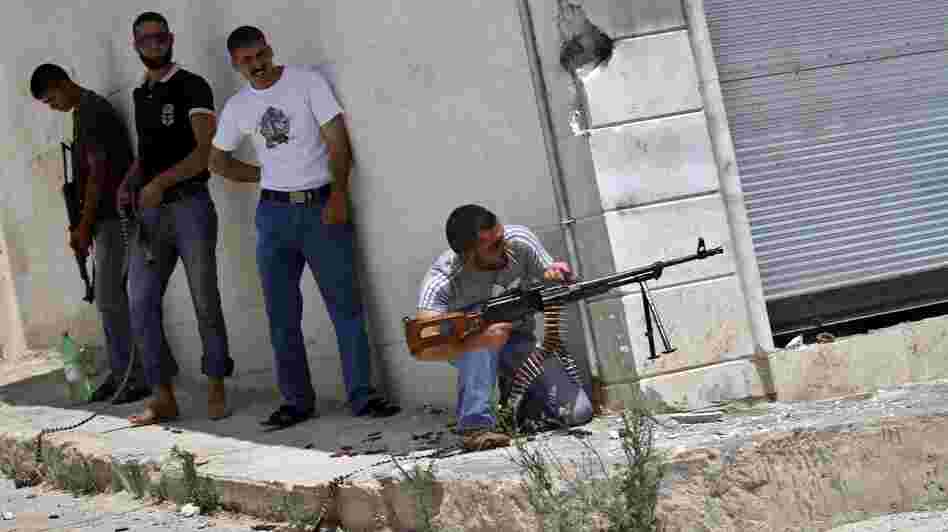 A Syrian rebel fires his weapon during clashes with Syrian troops near Idlib, in northern Syria, on June 15. The conflict has gone on for well over a year, but the international community has shown no appetite for a military intervention.