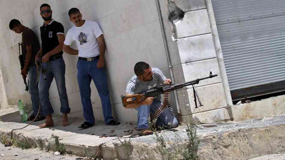 A Syrian rebel fires his weapon during clashes with Syrian troops near Idlib, in northern Syria, on June 15. The conflict has gone on for well over a year, but the international community has shown no appetite for a military intervention.