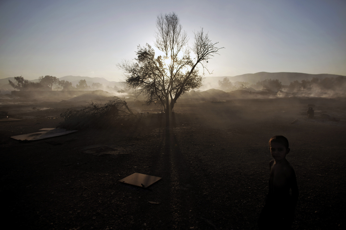 A Roma boy stands at a burnt Roma encampment, where the fire broke out in the industrial zone of Athens on Wednesday.