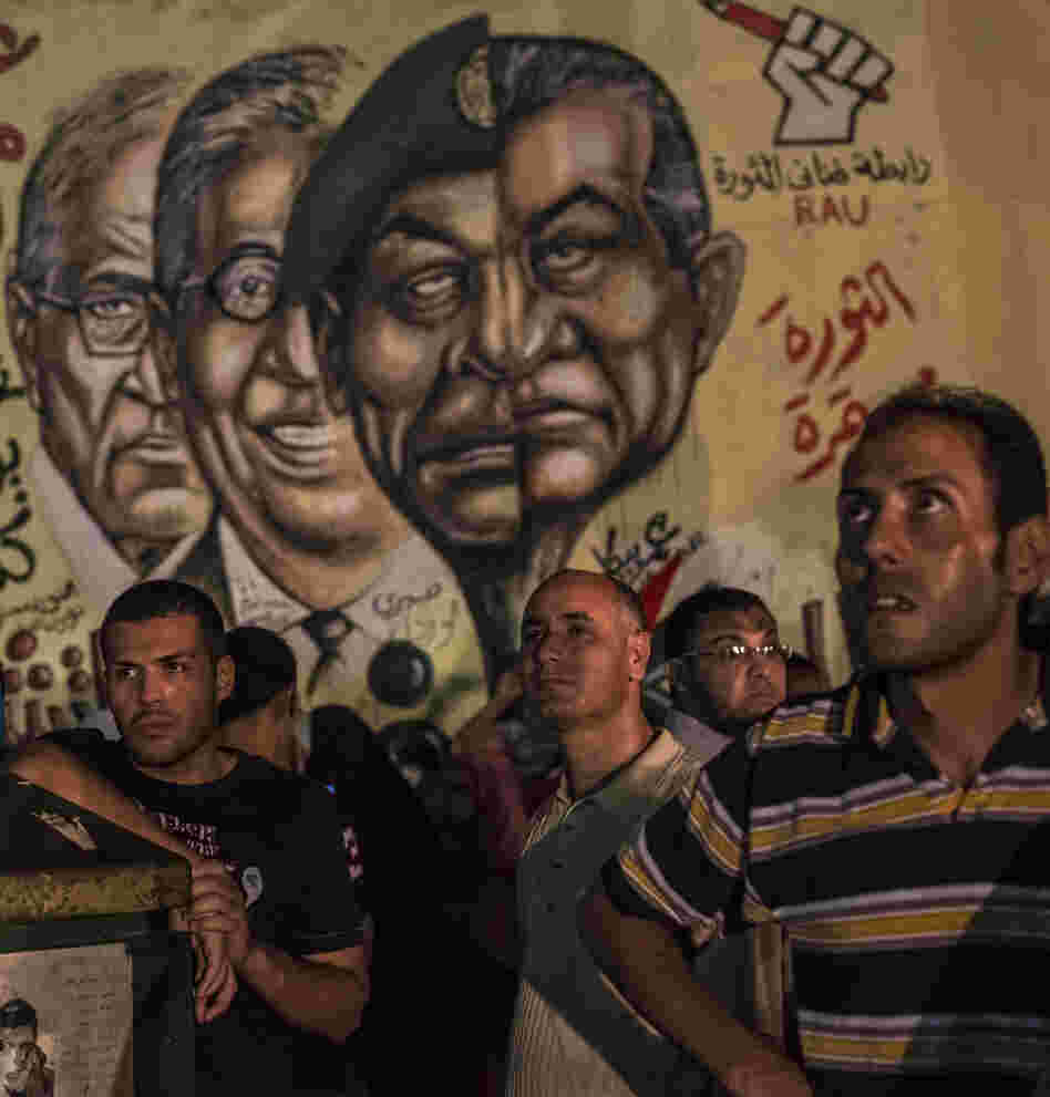 In Cairo's Tahrir Square on Tuesday night, men gathered in front of graffiti showing ousted President Hosni Mubarak and others from his regime.