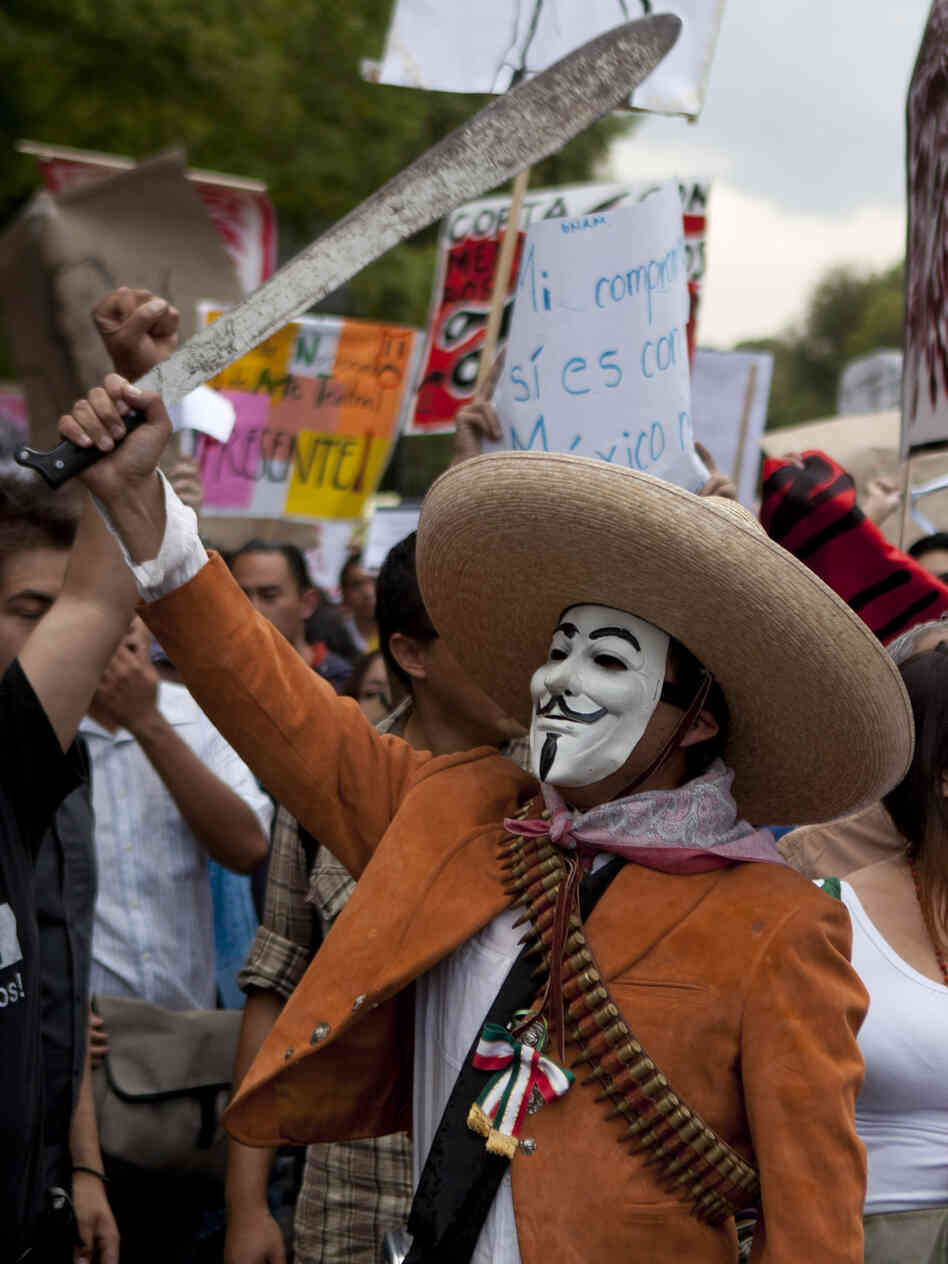 A man wearing a mask holds up a machete during a protest in May against a possible return of the old ruling Institutional Revolutionary Party in Mexico City.