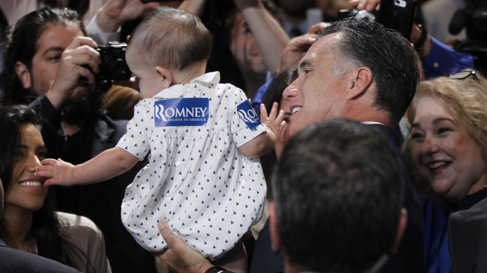Republican presidential candidate Mitt Romney gives a young supporter a boost at the National Association of Latino Elected and Appointed Officials conference in Orlando, Fla., on Thursday.