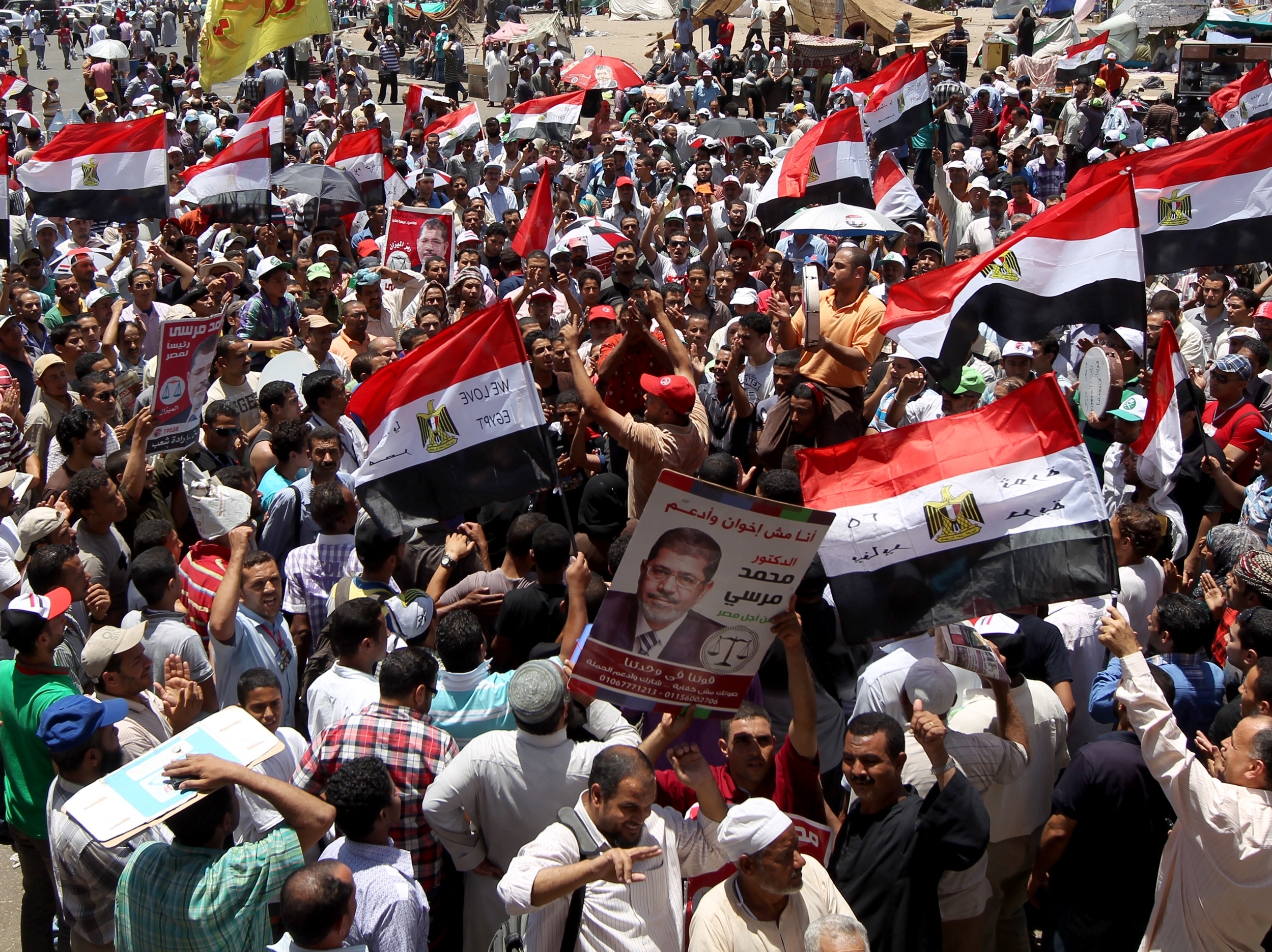 Supporters of the Muslim Brotherhood hold portraits of their candidate, Mohamed Morsi, as the they protest in Cairo's Tahrir square on June 21. Egypt was on edge after the Brotherhood declared an open-ended protest and warned of 'confrontation' unless their candidate is named president.