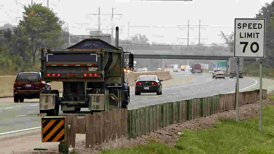 Traffic rolls past a speed limit sign in Ohio. Researchers believe they have found a new way to encourage drivers to stay within a safe driving speed: giving them a financial reward that diminishes as they speed.