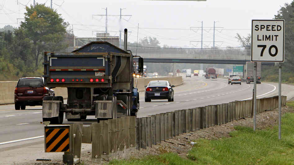 Traffic rolls past a speed limit sign in Ohio. Researchers believe they have found a new way to encourage drivers to stay within a safe driving speed: giving them a financial reward that diminishes as they speed.