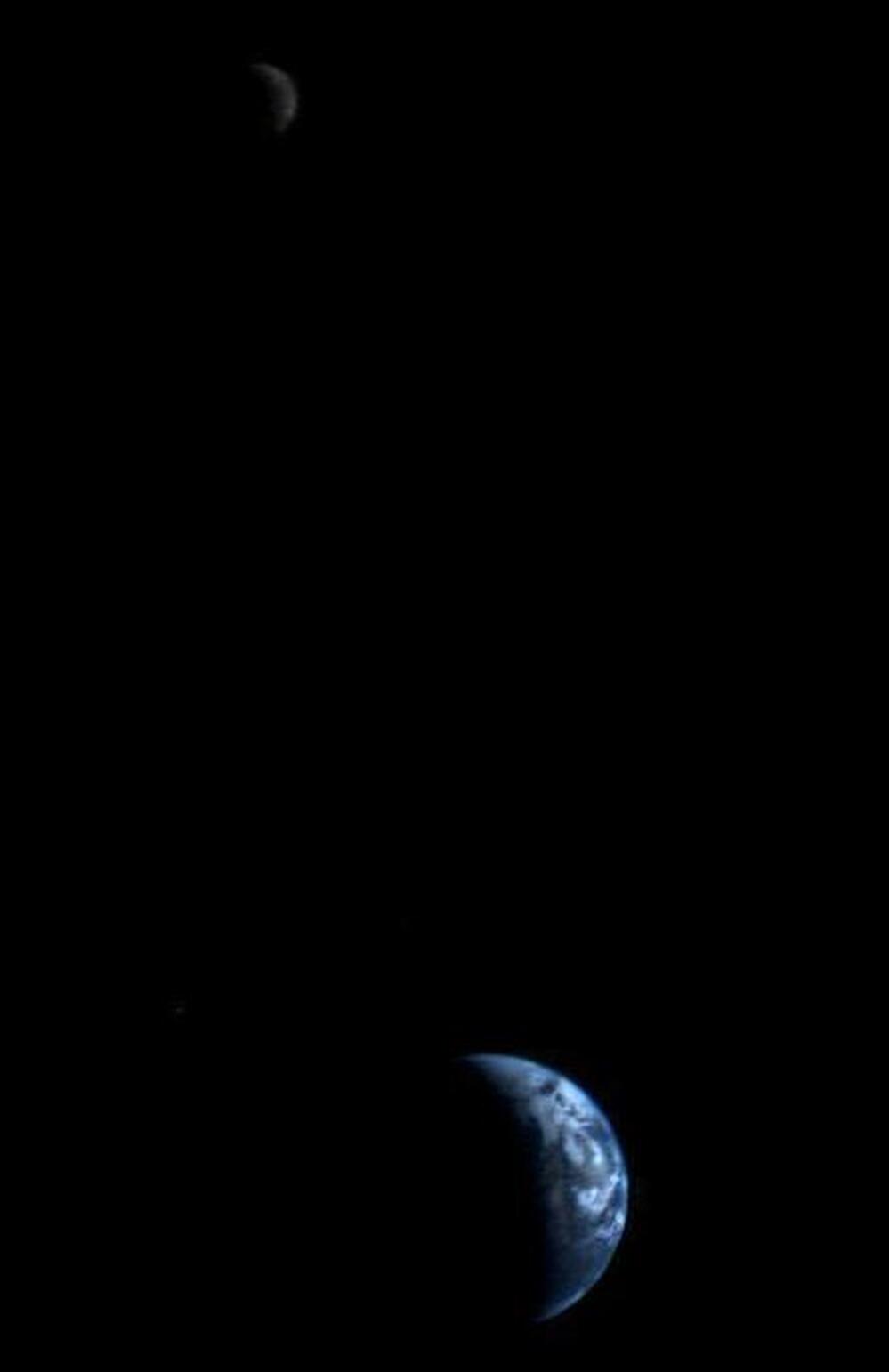 This image of the Earth and moon (upper left) in a single frame, the first of its kind ever taken by a spacecraft, was recorded by Voyager 1 on Sept. 18, 1977.