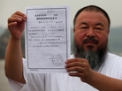 In a park in Beijing, Chinese artist Ai Weiwei holds a copy of a government document informing him of the expiry of his bail term. In a park in Beijing, Chinese artist Ai Weiwei holds a copy of a government document informing him of the expiry of his bail term.