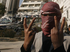 A Syrian youth flashes the victory sign as he stands in front of a building that was covered with anti-government graffiti — though local authorities painted over it — in the town of Duma, outside Damascus, in February. A Syrian youth flashes the victory sign as he stands in front of a building that was covered with anti-government graffiti — though local authorities painted over it — in the town of Duma, outside Damascus, in February.