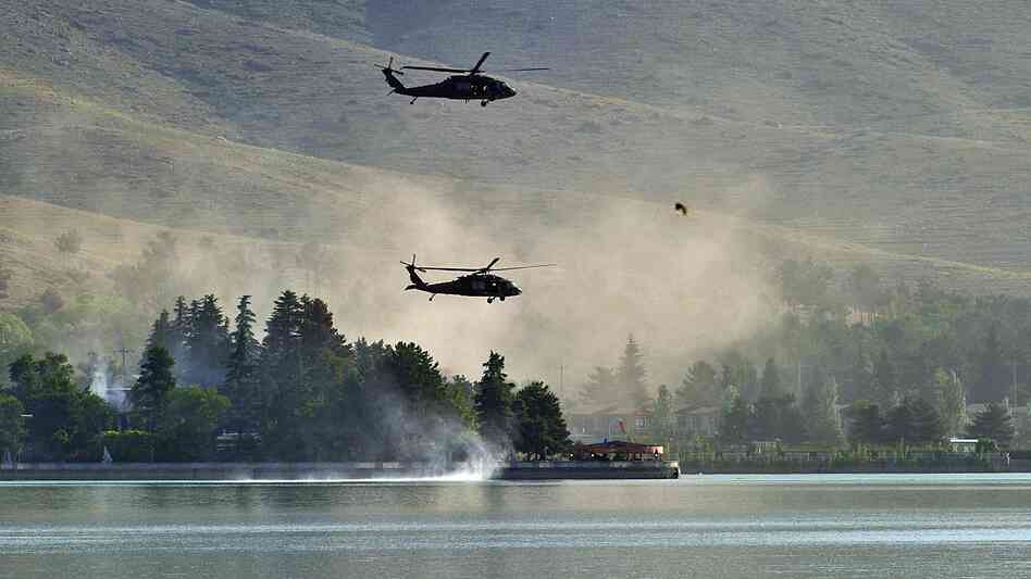 Responding to a Taliban attack, NATO Black Hawk helicopters fly over the Spozhmai Hotel on Lake Qargha outside Kabul. More than 20 people were killed before the Taliban fighters were shot dead. Responding to a Taliban attack, NATO Black Hawk helicopters fly over the Spozhmai Hotel on Lake Qargha outside Kabul. More than 20 people were killed before the Taliban fighters were shot dead.