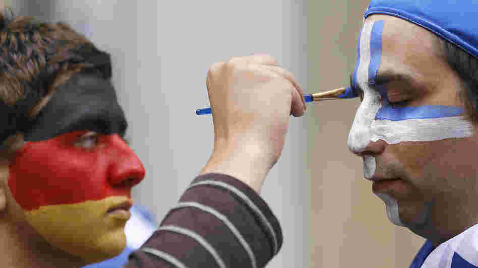 An artist with the German national colors on his face paints the Greek colors on a soccer fan in Gdansk, Poland, on Friday as Germany and Greece prepared to play in the quarterfinals of the Euro 2012 soccer championship. An artist with the German national colors on his face paints the Greek colors on a soccer fan in Gdansk, Poland, on Friday as Germany and Greece prepared to play in the quarterfinals of the Euro 2012 soccer championship.