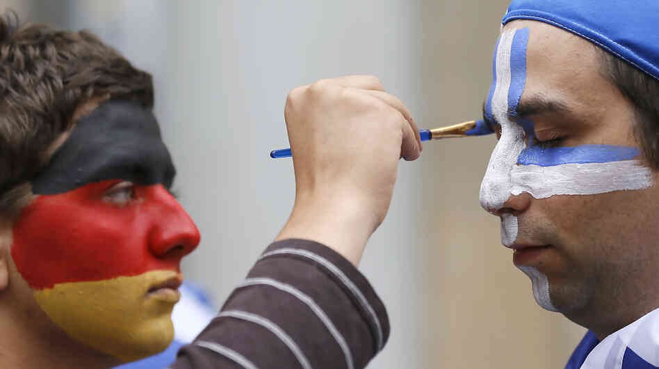 An artist with the German national colors on his face paints the Greek colors on a soccer fan in Gdansk, Poland, on Friday as Germany and Greece prepared to play in the quarterfinals of the Euro 2012 soccer championship. An artist with the German national colors on his face paints the Greek colors on a soccer fan in Gdansk, Poland, on Friday as Germany and Greece prepared to play in the quarterfinals of the Euro 2012 soccer championship.