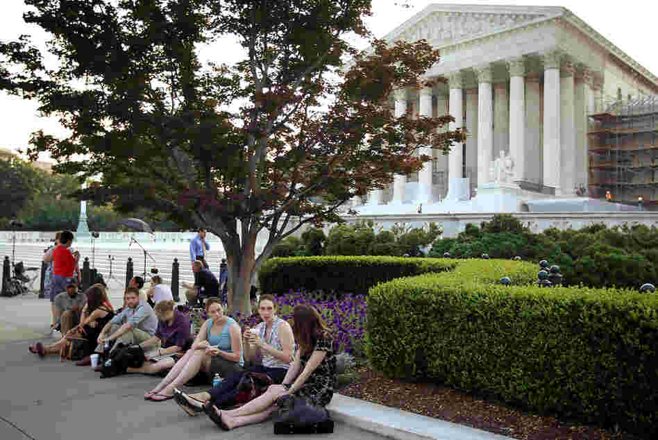 People wait outside the Supreme Court last week for word on the fate of the federal health overhaul law.
