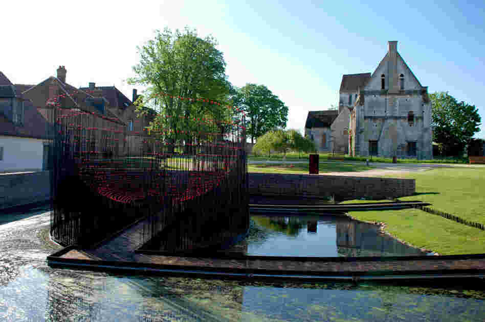 Andy Cao and Xavier Perrot's Red Bowl installation in Beauvais, France, allows visitors to cross a pond into a hemisphere of metal rods topped with red marbles.