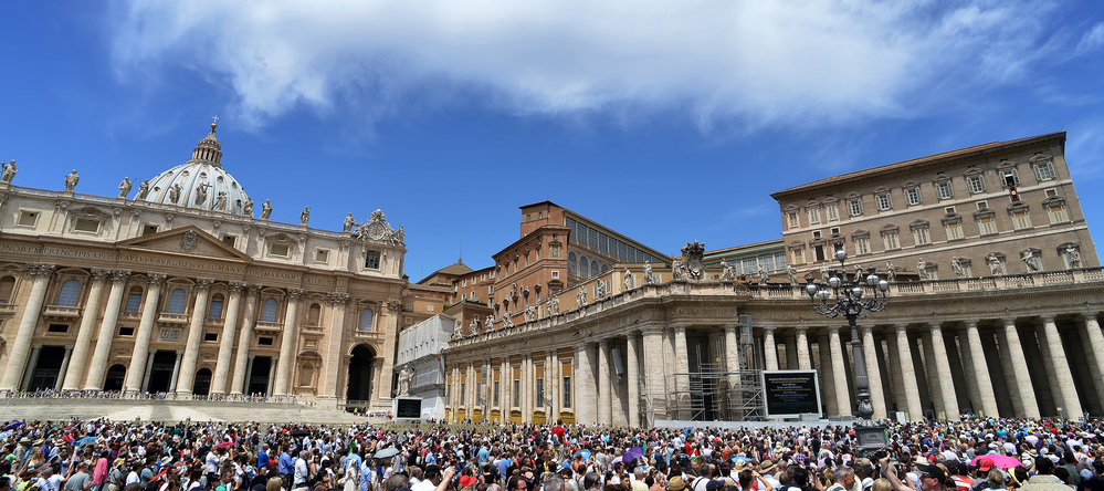 People gather on St. Peter's square to hear Pope Benedict XVI at the Vatican Sunday. The Vatican has hired Fox News correspondent Greg Burke to advise its press office.