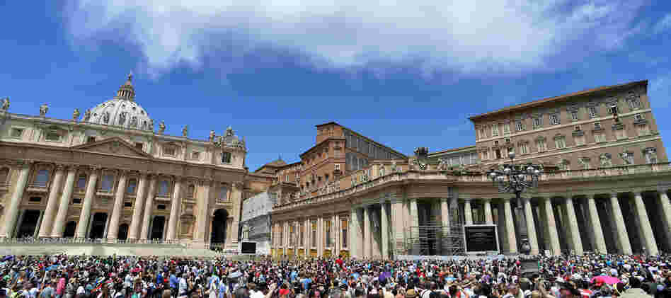 People gather on St. Peter's square to hear Pope Benedict XVI at the Vatican Sunday. The Vatican has hired Fox News correspondent Greg Burke to advise its press office.