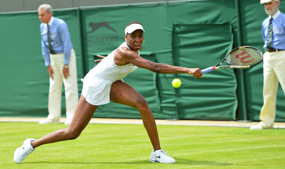 Venus Williams stretches for a return in her first-round defeat to Russia's Elena Vesnina on the first day of the Wimbledon Championships. For Williams, 32, it was her earliest exit from Wimbledon in 15 years.