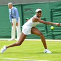 Venus Williams stretches for a return in her first-round defeat to Russia's Elena Vesnina on the first day of the Wimbledon Championships. For Williams, 32, it was her earliest exit from Wimbledon in 15 years.