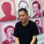 Artist and filmmaker Zhang Bingjian sits in his Beijing studio in front of his Hall of Fame — portraits of corrupt Chinese officials. He has commissioned portraits of 1,600 officials convicted of corruption.