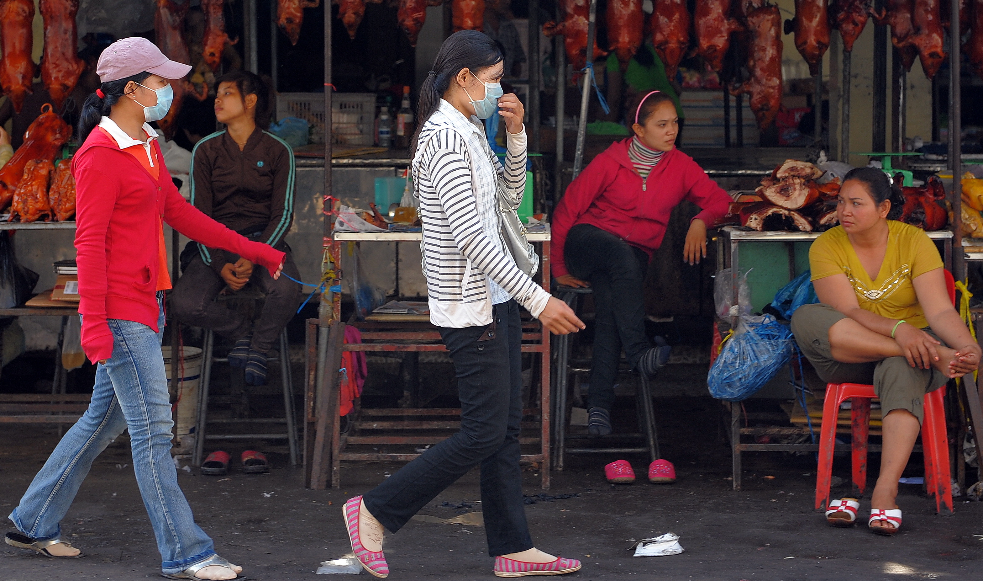 Cambodian women wear masks as they walk in a market in Phnom Penh in Oct. 2009. That month a second Cambodian died from swine flu, health officials said.